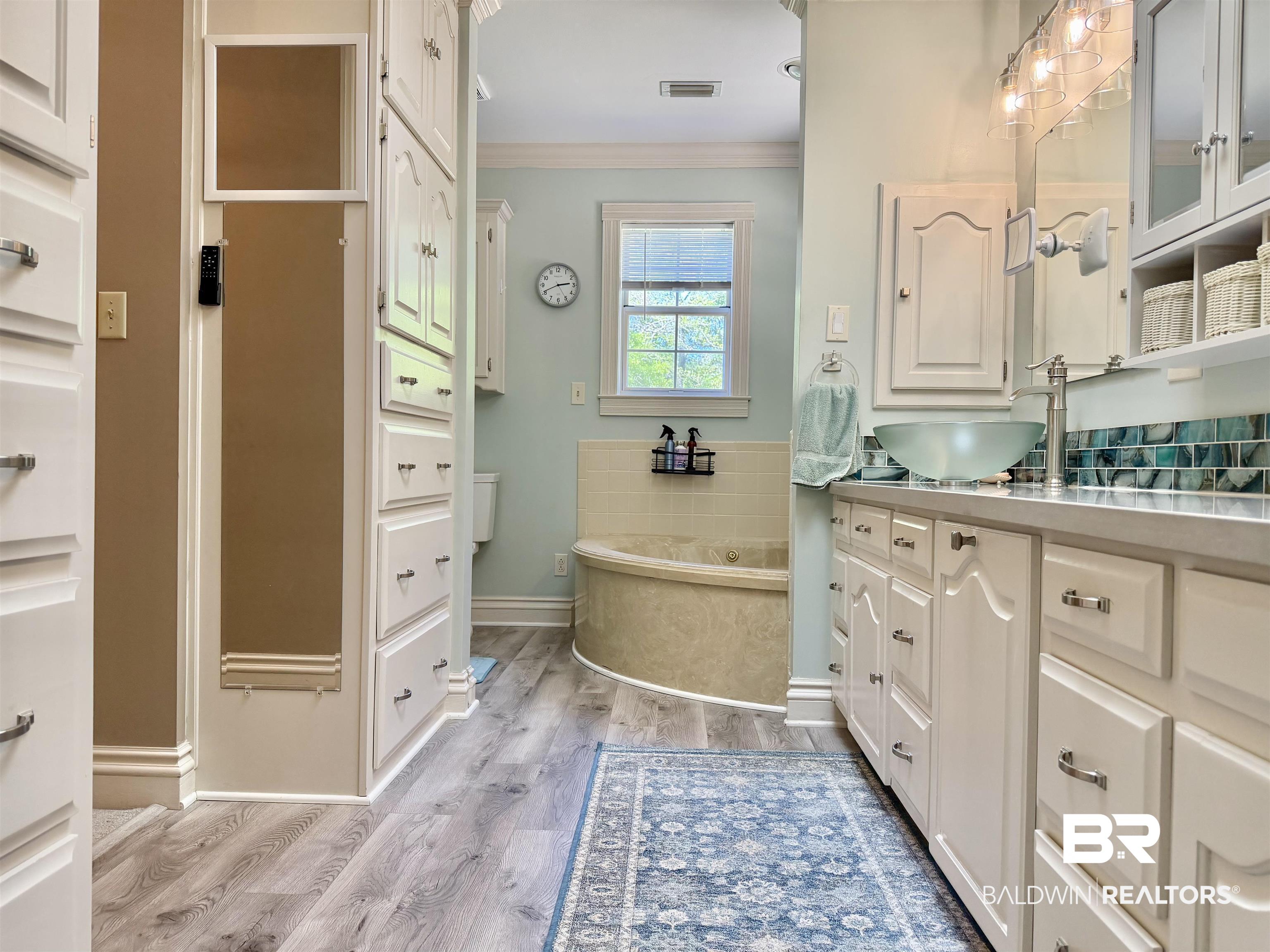 2944 Appleton Road Brewton, AL 36426 - Photo 18 of 65 Bathroom featuring crown molding, light wood finished floors, vanity, and a bath