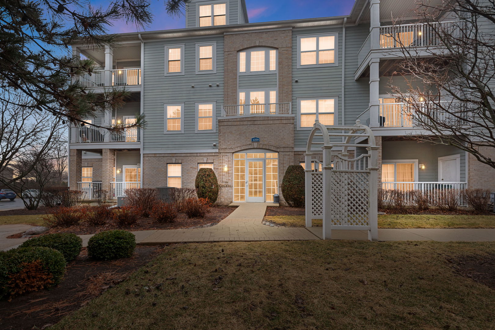 a front view of a residential apartment building with a yard