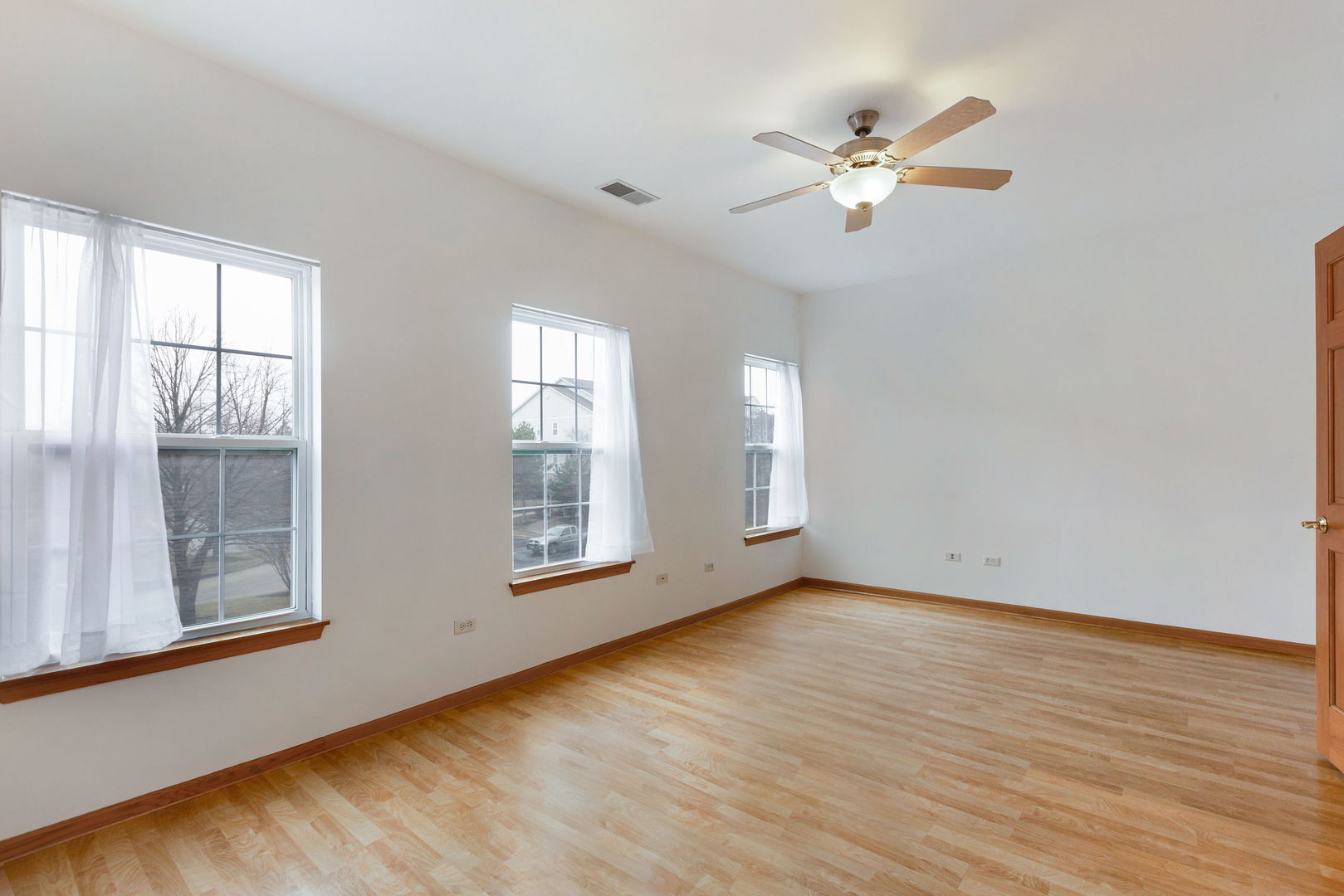 1259 West Lake Street, Unit 203 Addison, IL 60101 - Photo 13 of 17 an empty room with wooden floor fan and windows