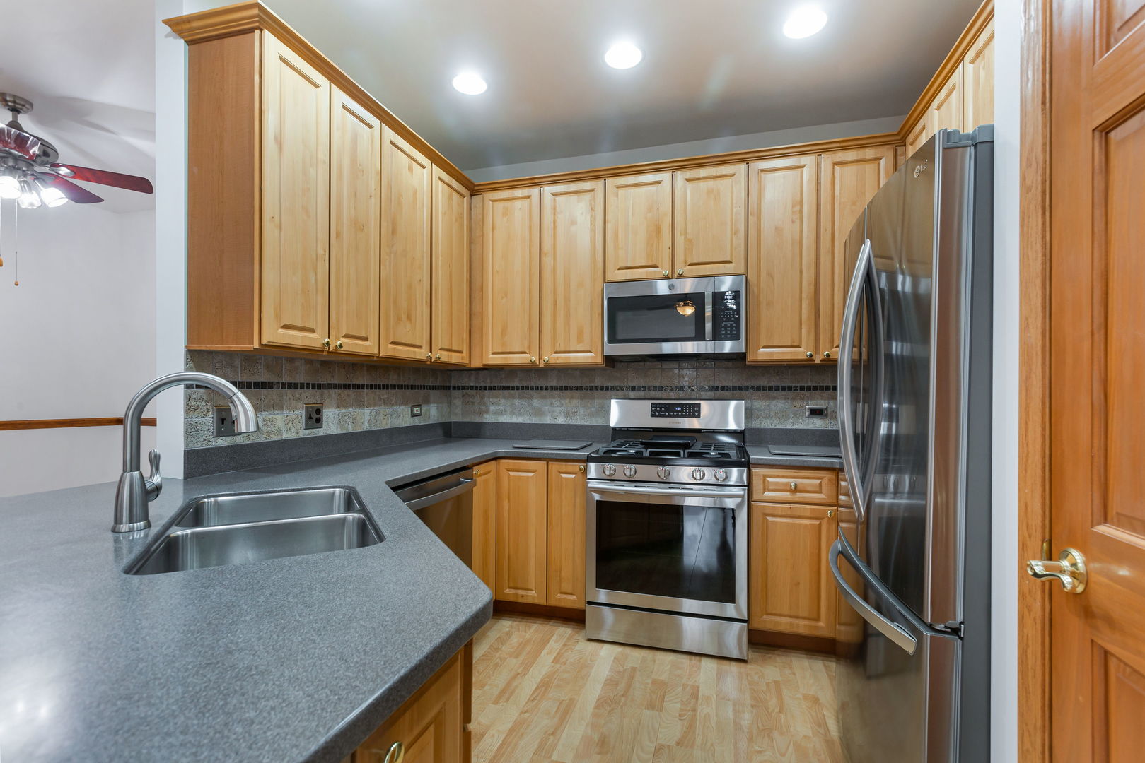 1259 West Lake Street, Unit 203 Addison, IL 60101 - Photo 5 of 17 a kitchen with stainless steel appliances granite countertop a stove a sink and a microwave
