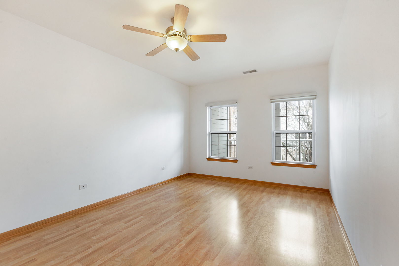 1259 West Lake Street, Unit 203 Addison, IL 60101 - Photo 9 of 17 an empty room with wooden floor fan and windows