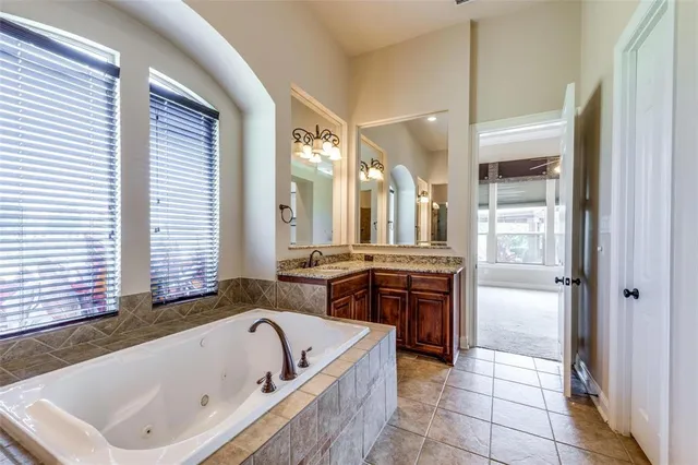 a spacious bathroom with a bathtub sink and mirror