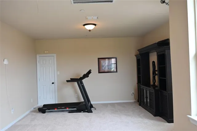 a room with gym equipment and a ceiling fan