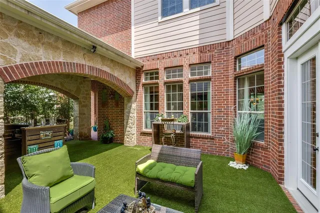a view of a chair and table in back yard of the house