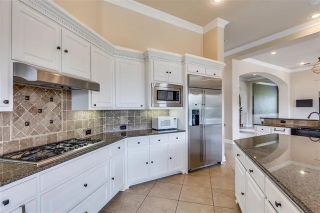 a kitchen with stainless steel appliances granite countertop a sink stove refrigerator and cabinets