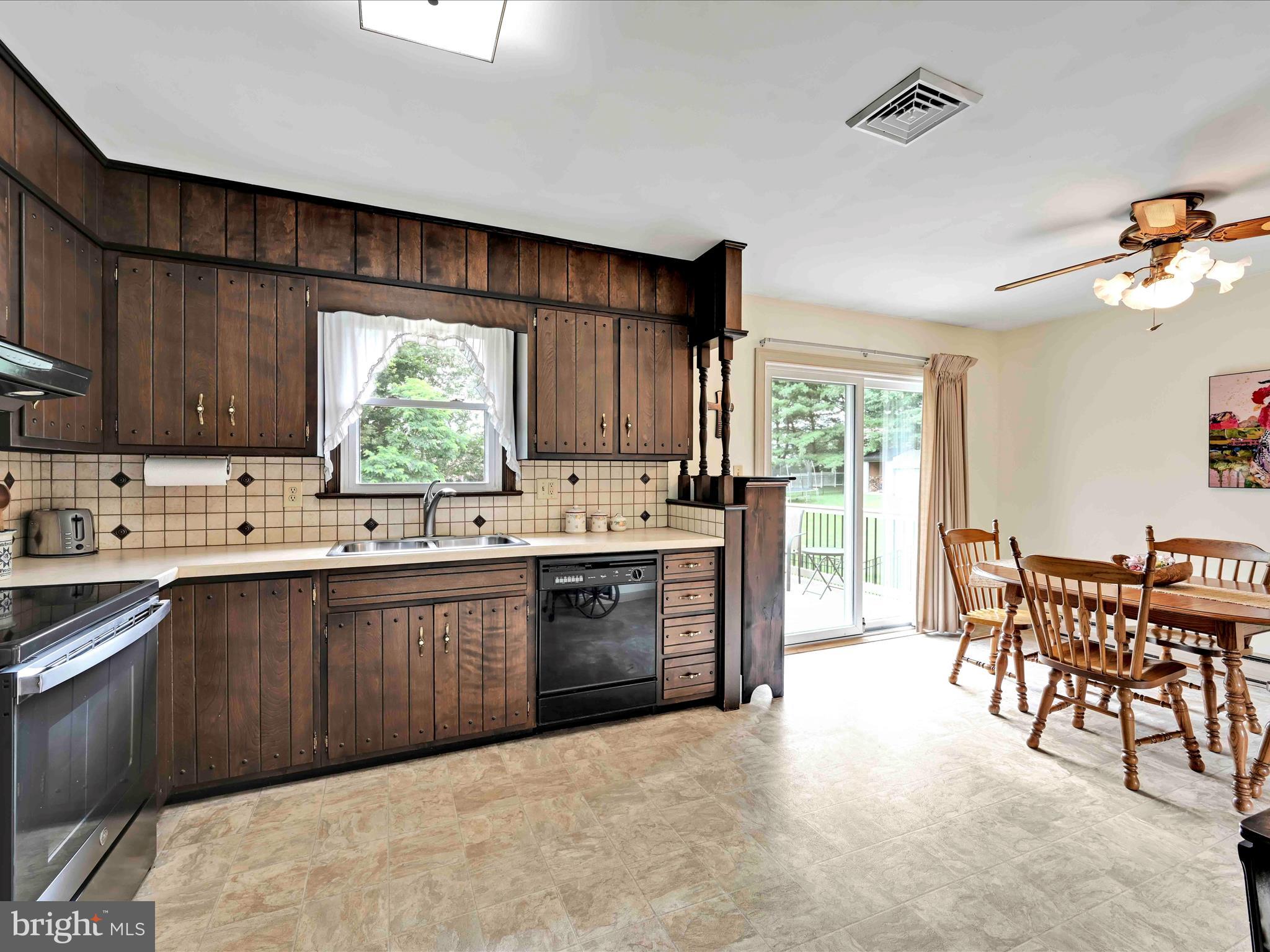 301 Owl Hill Road Lititz, PA 17543 - Photo 7 of 35 a kitchen with stainless steel appliances granite countertop a stove top oven a sink dishwasher a dining table and chairs with wooden floor