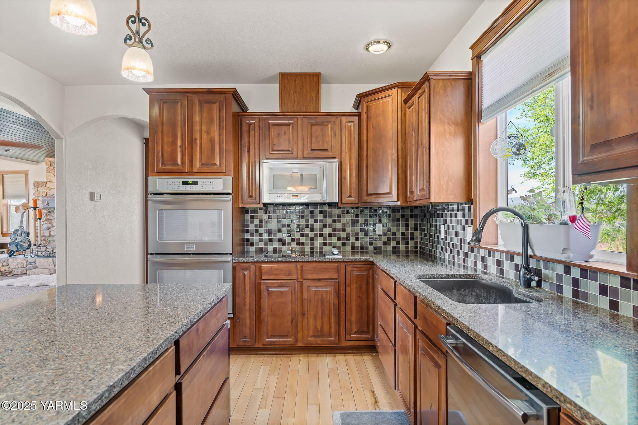 12900 Douglas Road Yakima, WA 98908 - Photo 16 of 62 a kitchen with stainless steel appliances granite countertop a sink a stove and a wooden cabinets