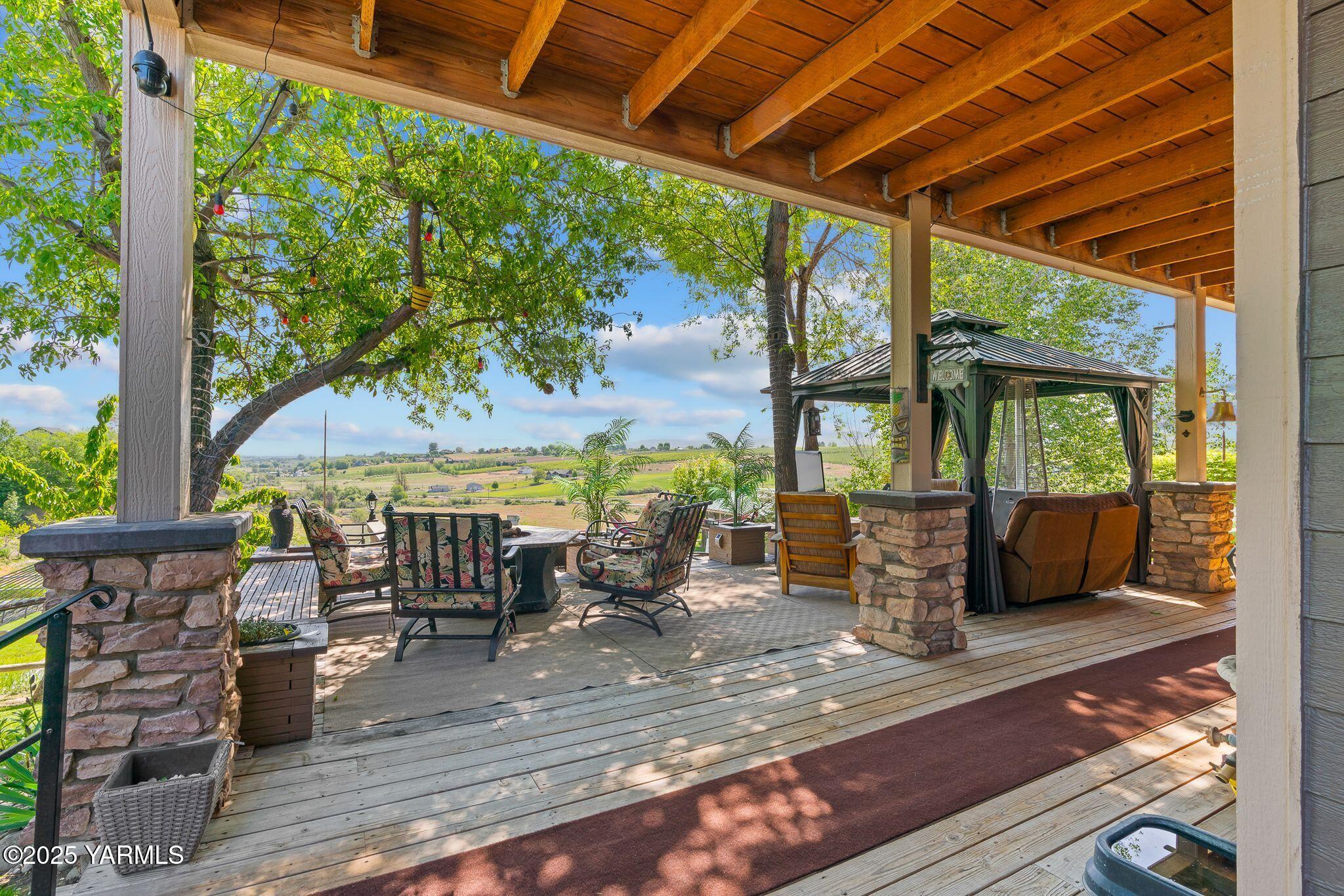 12900 Douglas Road Yakima, WA 98908 - Photo 50 of 62 a view of a patio with table and chairs potted plants with wooden floor and floor to ceiling window