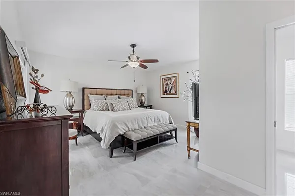 a bedroom with a bed and a flat tv screen on dresser