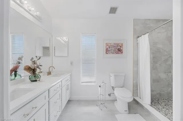 a en suite bathroom with double sink and a large mirror