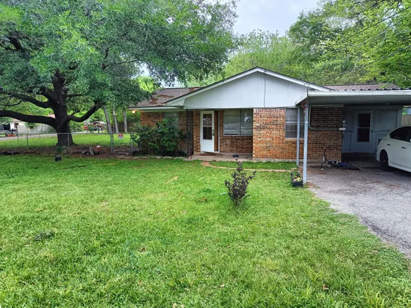 a view of a house with a yard and large trees