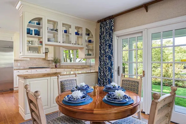 a dining room with fireplace a couch and a floor to ceiling window