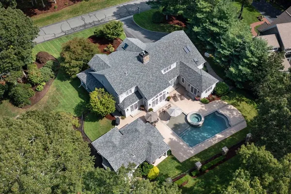 an aerial view of a house with yard and trees