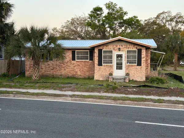 a front view of house with yard and trees around