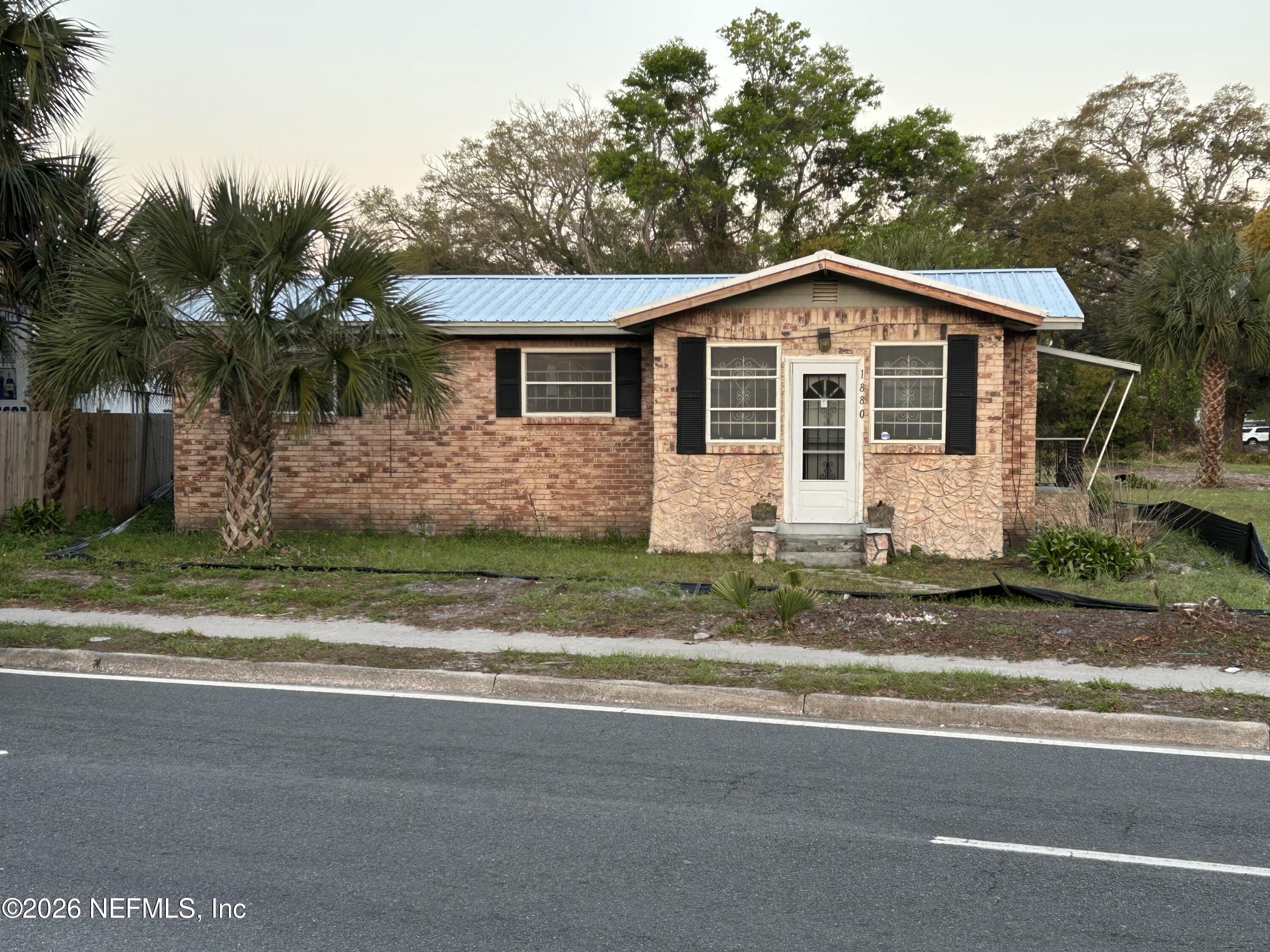 a front view of house with yard and trees around