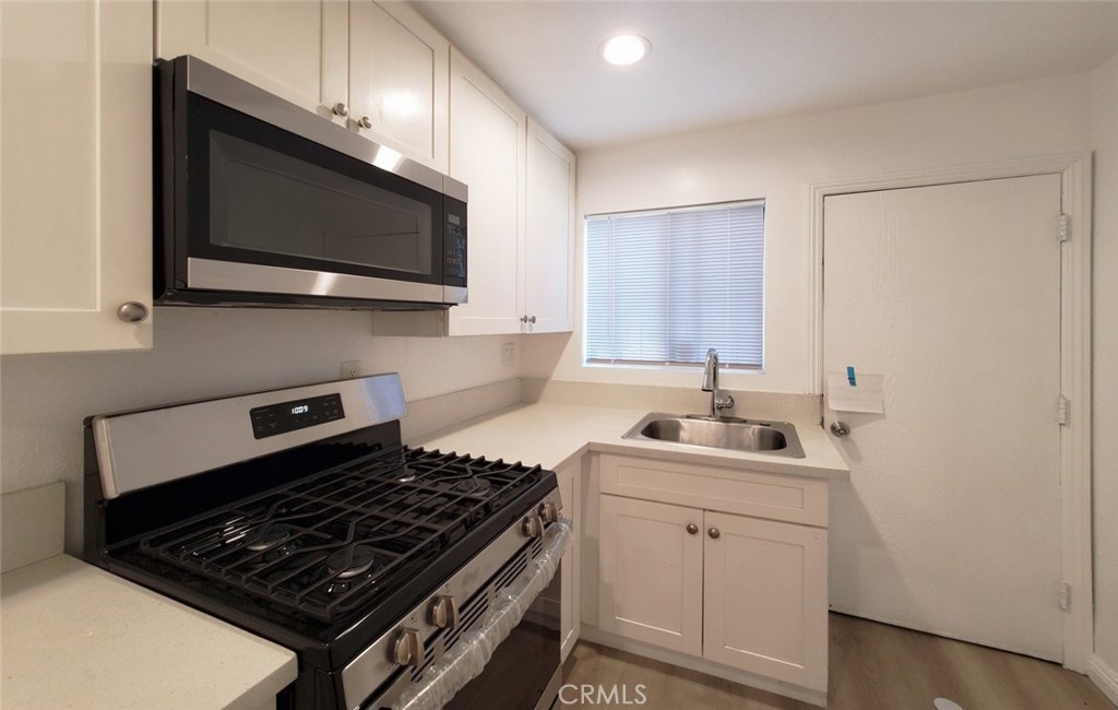 2020 West 23rd Street, Unit 17 Long Beach, CA 90810 - Photo 16 of 28 a kitchen with stainless steel appliances a sink dishwasher stove microwave and cabinets