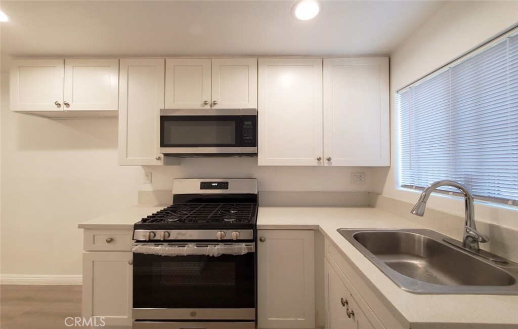 2020 West 23rd Street, Unit 17 Long Beach, CA 90810 - Photo 18 of 28 a kitchen with cabinets stainless steel appliances and a sink