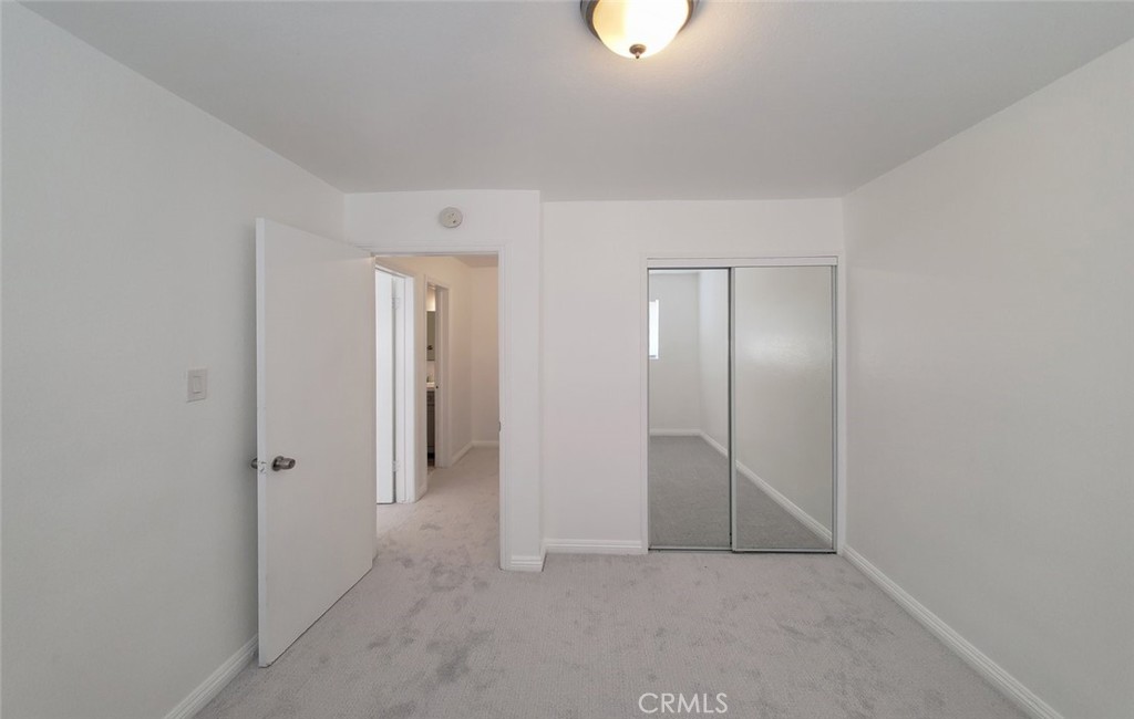 2020 West 23rd Street, Unit 17 Long Beach, CA 90810 - Photo 25 of 28 an empty room with closet and mirror