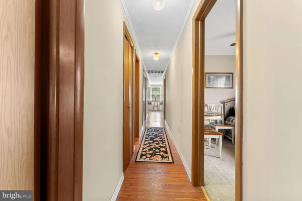 a view of a hallway with wooden floor and staircase