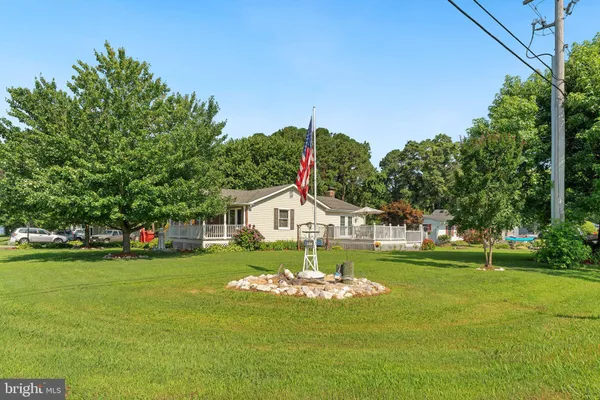 a view of a house with a big yard and potted plants