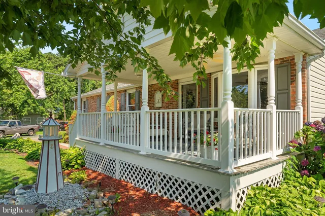a porch with a bench next to a yard
