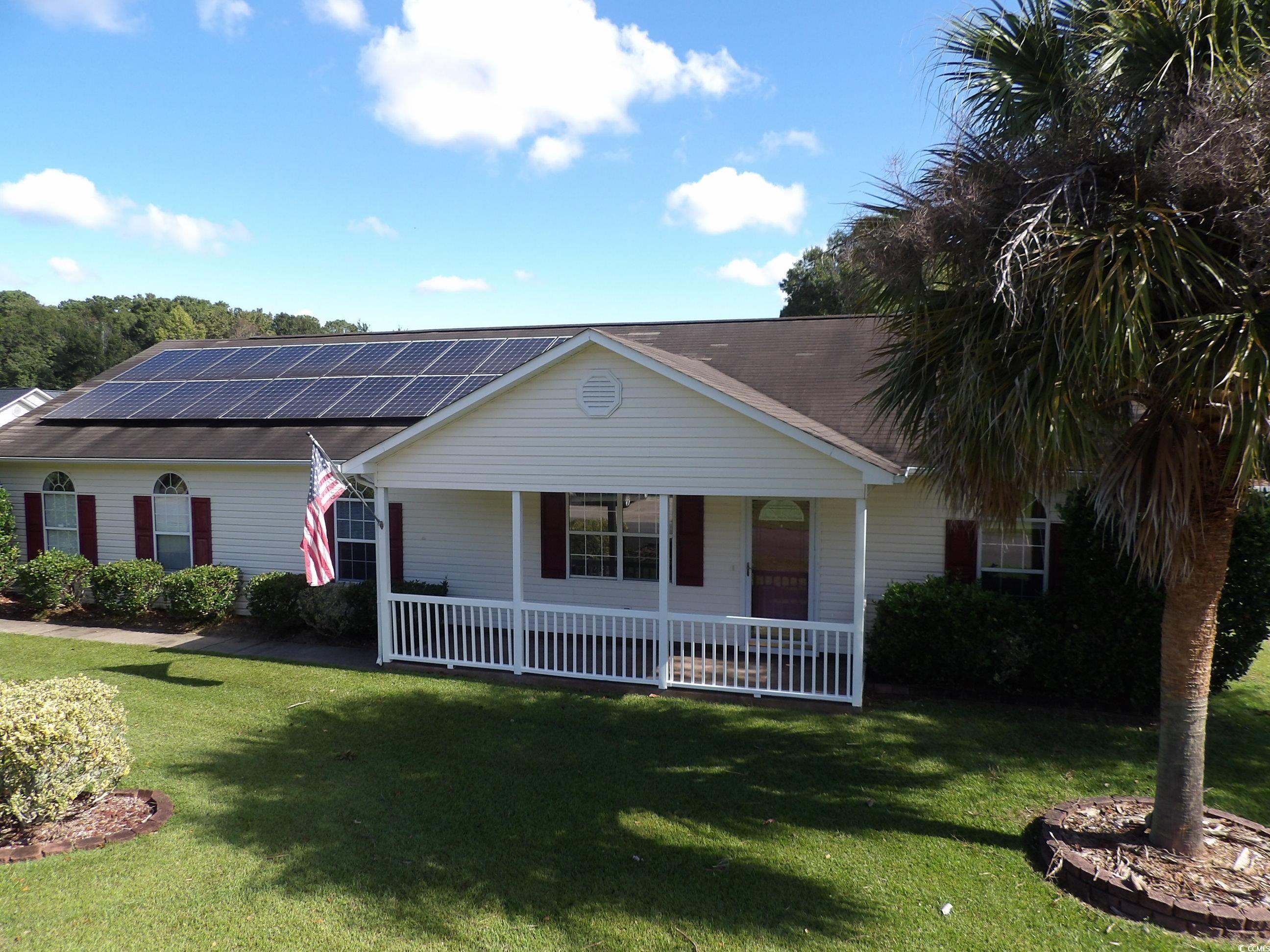 7971 Spruce Lane Murrells Inlet, SC 29576 - Photo 1 of 27 Ranch-style house with solar panels, a front lawn,