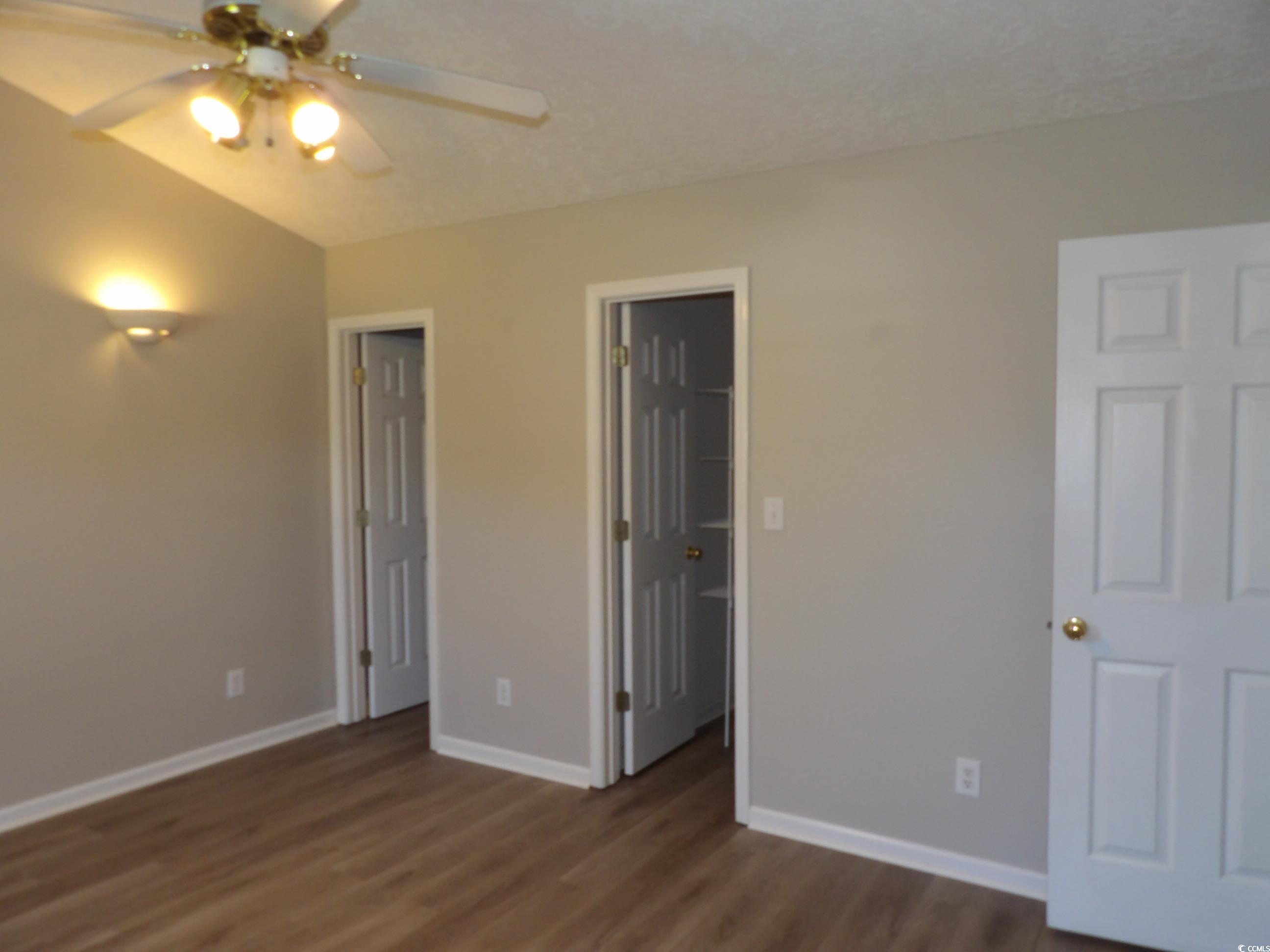 7971 Spruce Lane Murrells Inlet, SC 29576 - Photo 16 of 27 Unfurnished bedroom with ceiling fan and dark wood