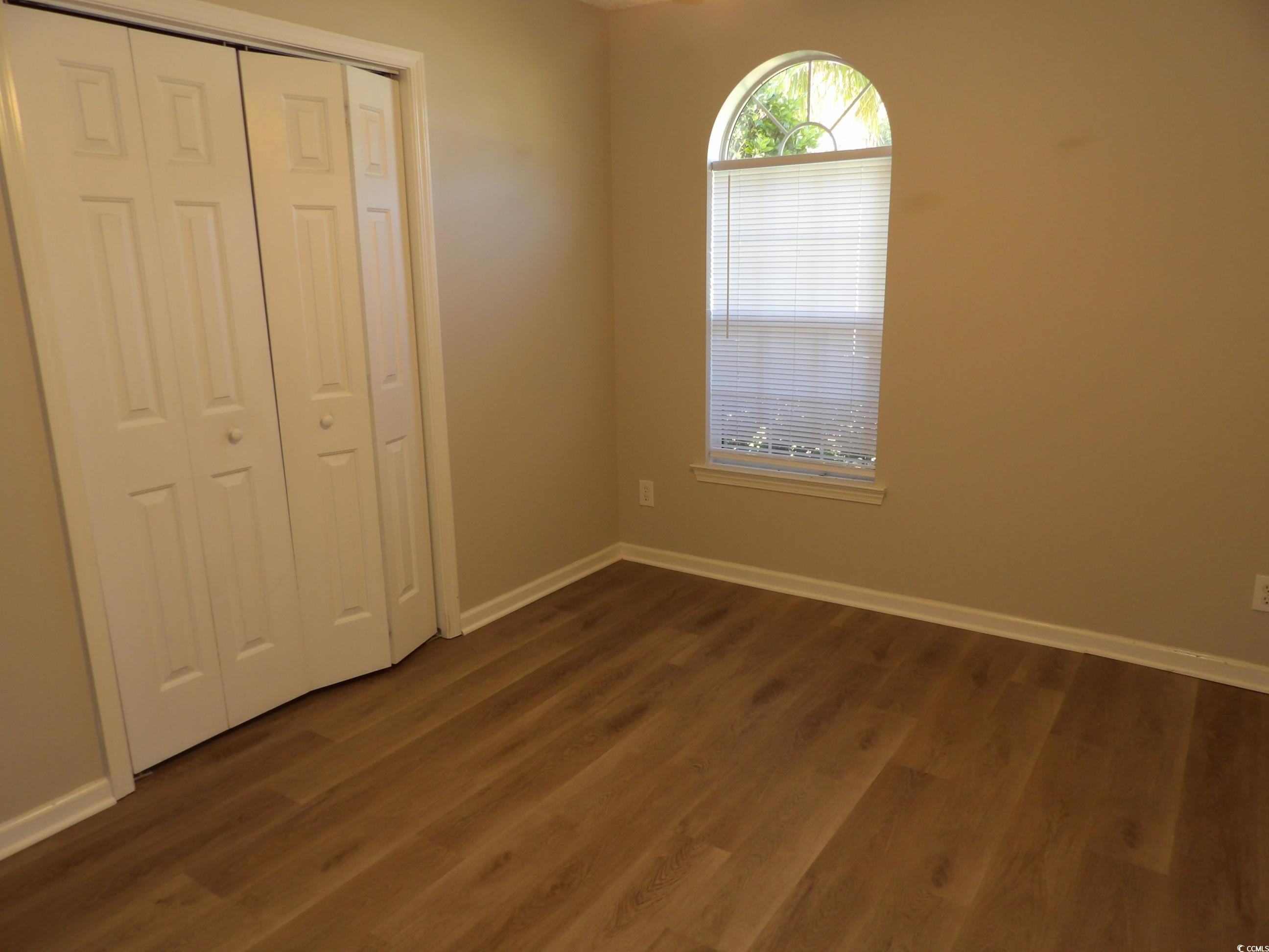 7971 Spruce Lane Murrells Inlet, SC 29576 - Photo 17 of 27 Unfurnished bedroom with a closet and dark hardwoo