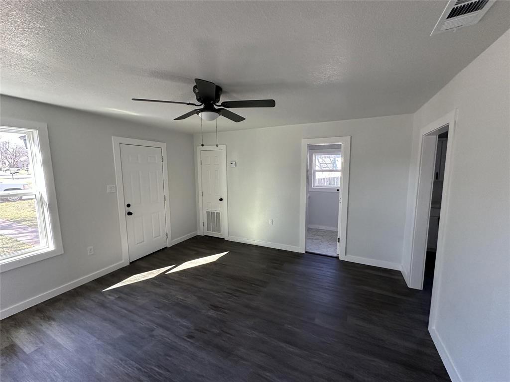 401 Walker Street Glen Rose, TX 76043 - Photo 2 of 10 a view of an empty room with wooden floor and a window