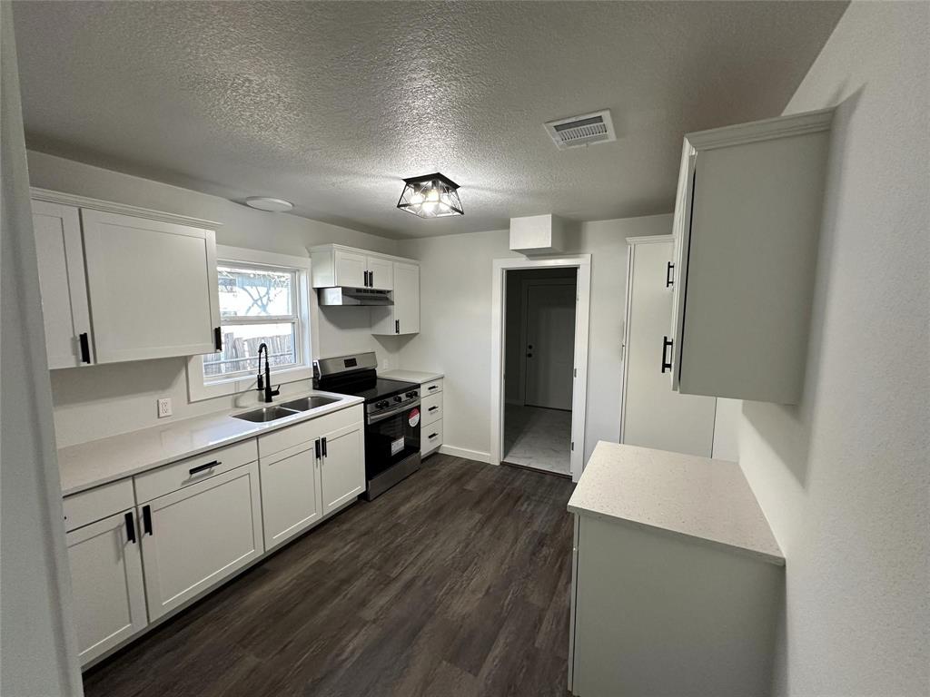 401 Walker Street Glen Rose, TX 76043 - Photo 4 of 10 a kitchen with a sink a counter top space stainless steel appliances and cabinets