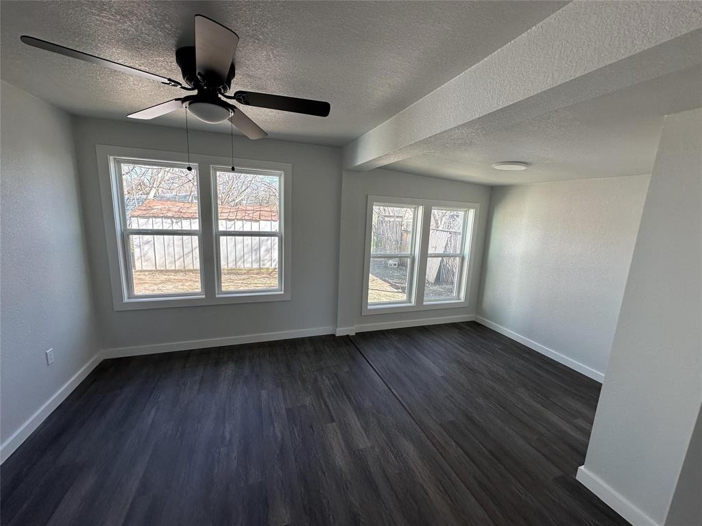 401 Walker Street Glen Rose, TX 76043 - Photo 7 of 10 a view of an empty room with wooden floor and a window