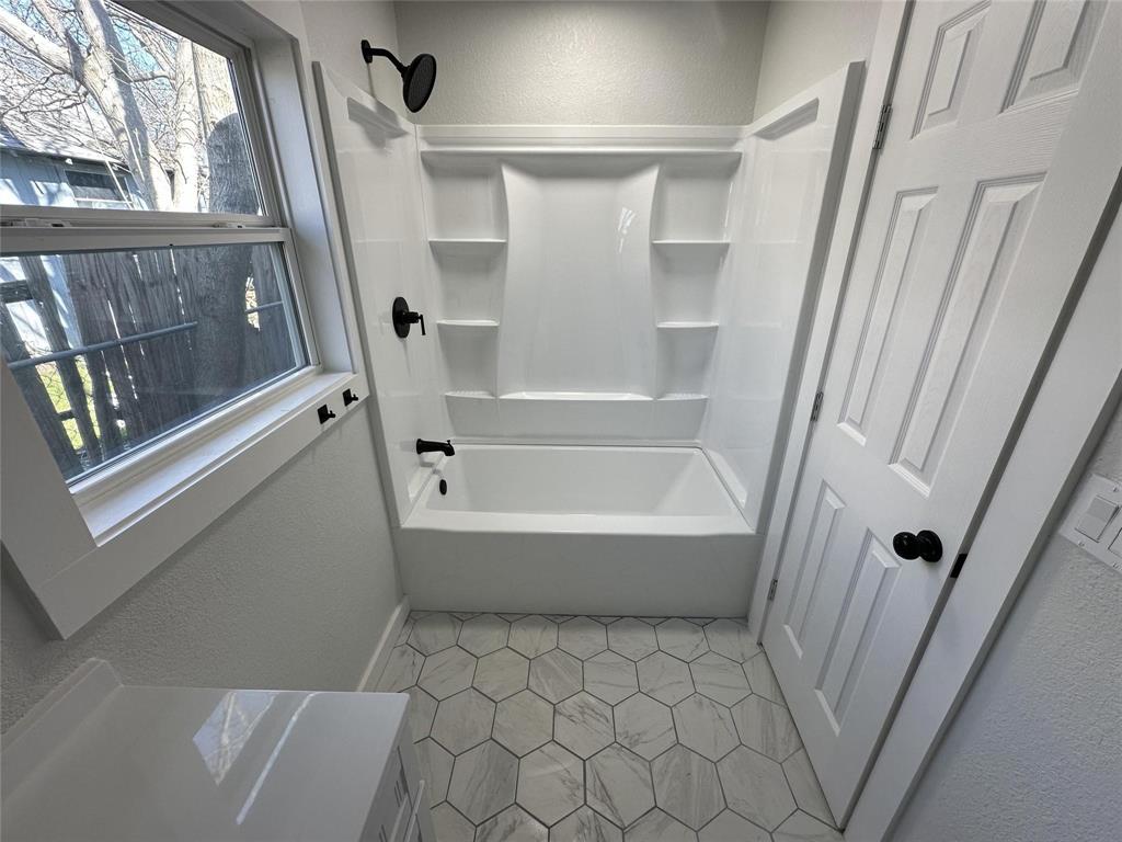 401 Walker Street Glen Rose, TX 76043 - Photo 9 of 10 a bathroom with a bathtub and a shower