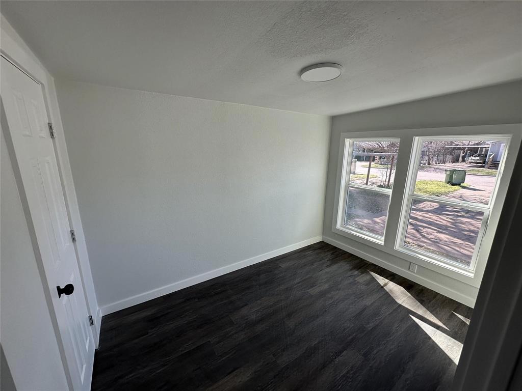 401 Walker Street Glen Rose, TX 76043 - Photo 10 of 10 a view of an empty room with wooden floor and a window