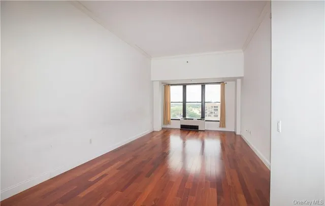 a view of a room with wooden floor and a ceiling fan