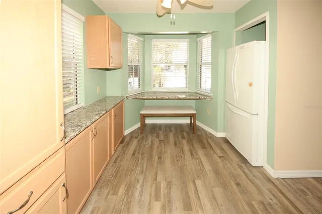 a view of a livingroom with wooden floor and a ceiling fan