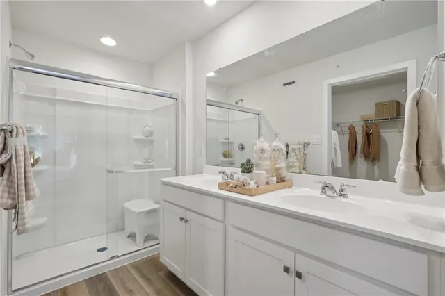 a bathroom with double sink shower and a mirror