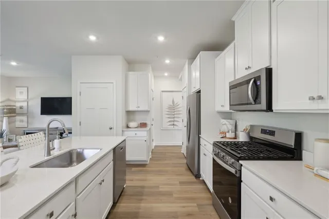 a kitchen with stainless steel appliances a sink stove top oven and refrigerator