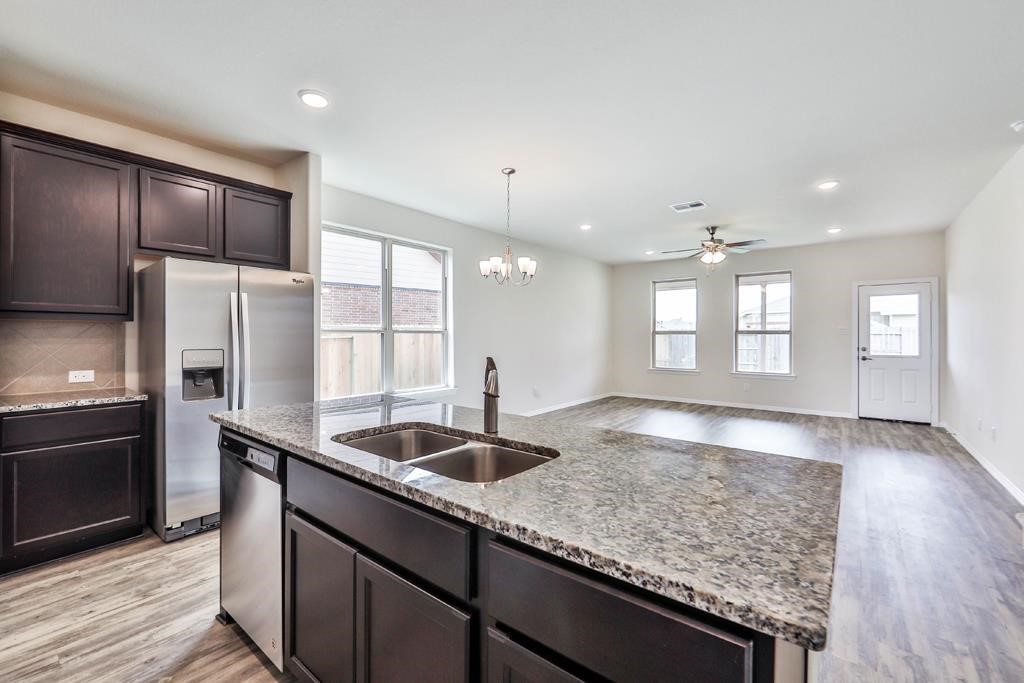 247 Sintra Lk Way Rosenberg, TX 77469 - Photo 9 of 28 a kitchen with granite countertop kitchen island a sink appliances and a counter space