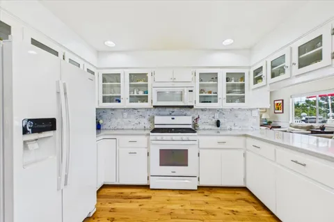 a kitchen with granite countertop a sink window and cabinets