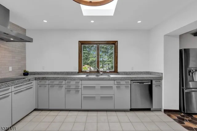 a kitchen with stainless steel appliances a sink and a refrigerator