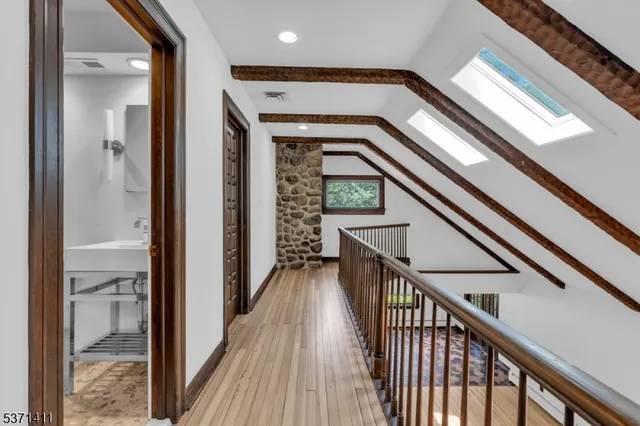 a view of a hallway with wooden floor and stairs