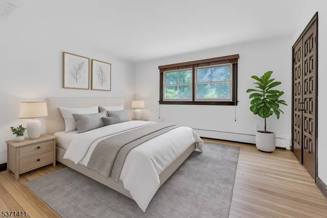 a spacious bedroom with a bed and a potted plant