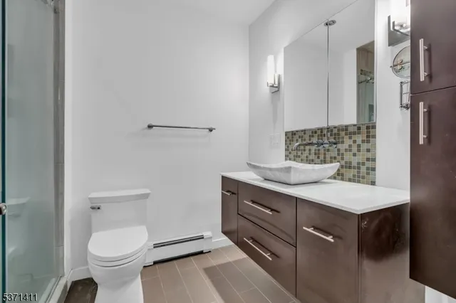 a bathroom with a granite countertop toilet sink and mirror