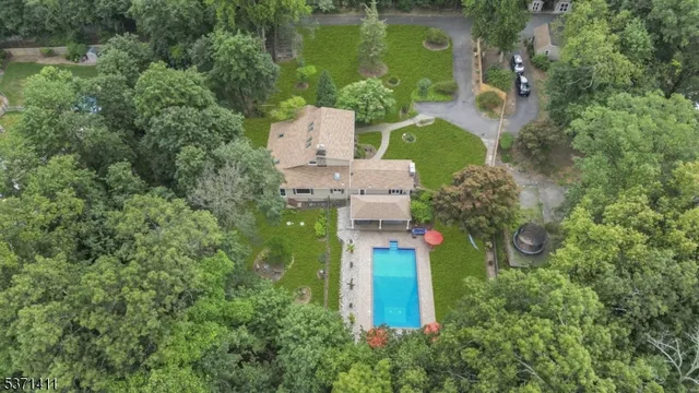 an aerial view of a house with outdoor space and tennis court
