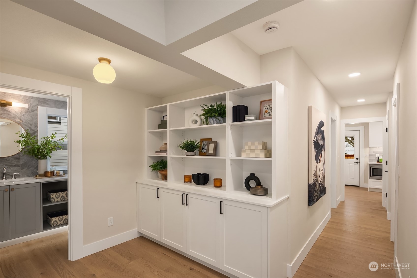 8021 Wallingford Avenue North Seattle, WA 98103 - Photo 12 of 39 a hallway with white cabinets and wooden floor