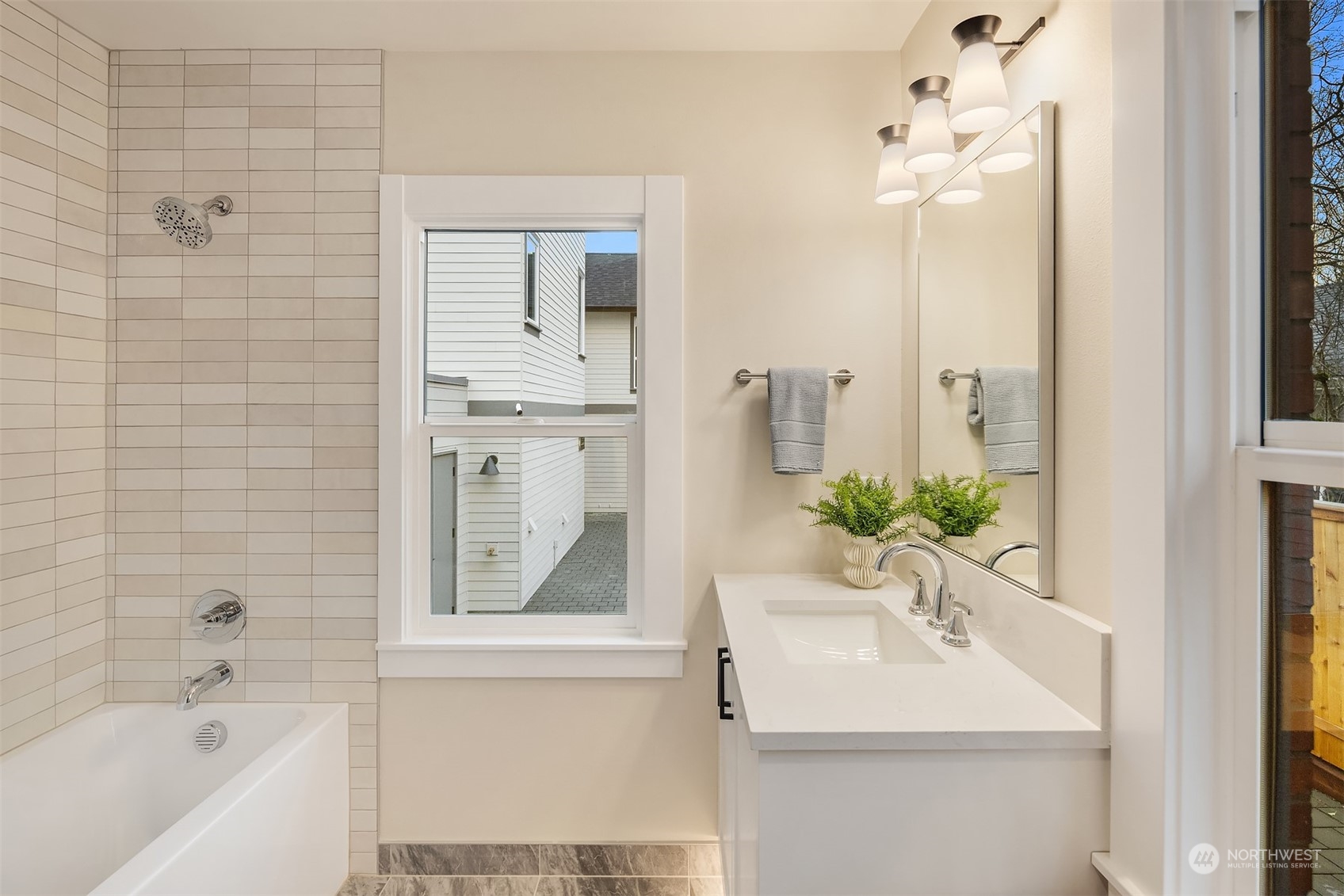 8021 Wallingford Avenue North Seattle, WA 98103 - Photo 15 of 39 a bathroom with a sink a mirror and a bathtub