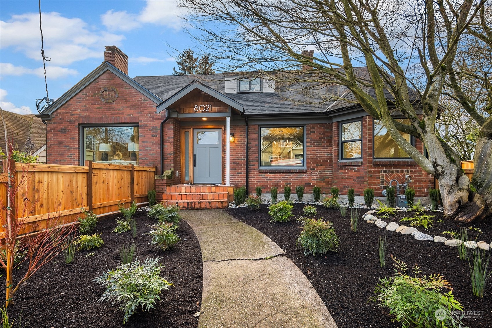 8021 Wallingford Avenue North Seattle, WA 98103 - Photo 35 of 39 a front view of a house with a yard outdoor seating and covered with trees