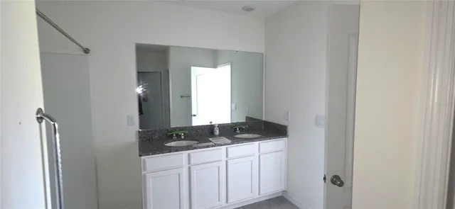 a bathroom with a granite countertop sink and a mirror