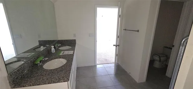 a bathroom with a granite countertop sink and a mirror
