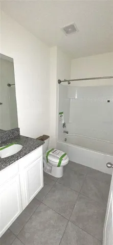 a bathroom with a granite countertop sink a toilet and a shower
